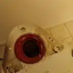 Toilet base opening with red wax ring
