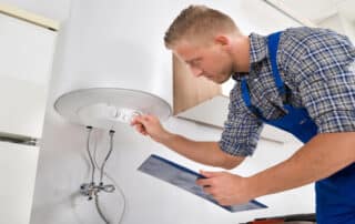Technician adjusting home water heater settings.
