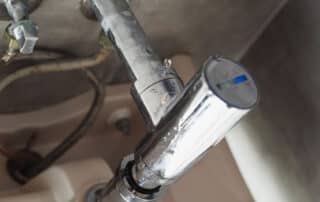Metal faucet with visible plumbing underneath