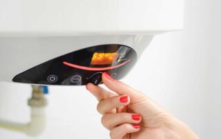 Person adjusting the digital controls on a modern water heater, checking temperature settings to diagnose why there is no hot water in the morning but normal heat later in the day. Image highlights troubleshooting steps for inconsistent water heater performance.