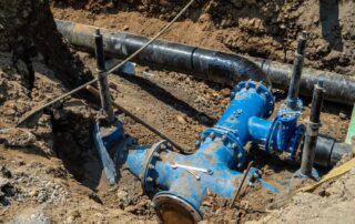 Cardom Plumbing and Heating explains the Pros and Cons of Trenchless Sewer Repair. Underground water pipe installation with blue fittings for sewers.