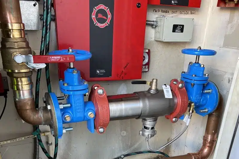 backflow-prevention-arvada-img-02 Industrial pipe system with red and blue valves.