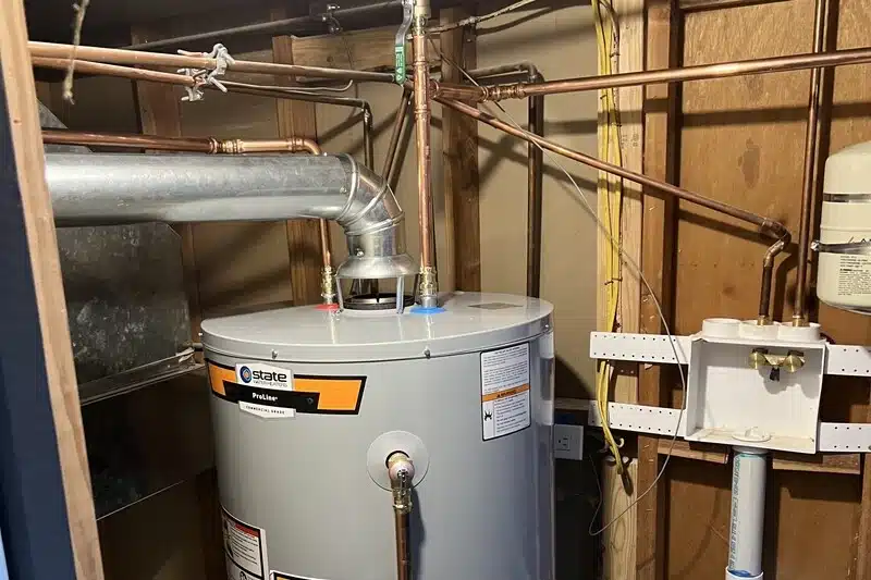 cardom-plumbing-heating-arvada-img-02 Installed water heater with copper pipes in utility room.