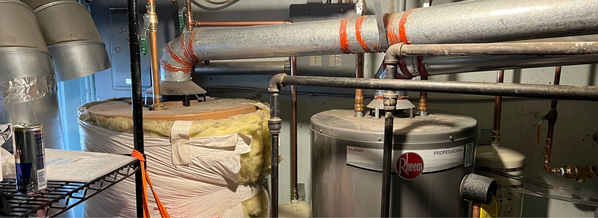 Boiler room with water heater and pipes.